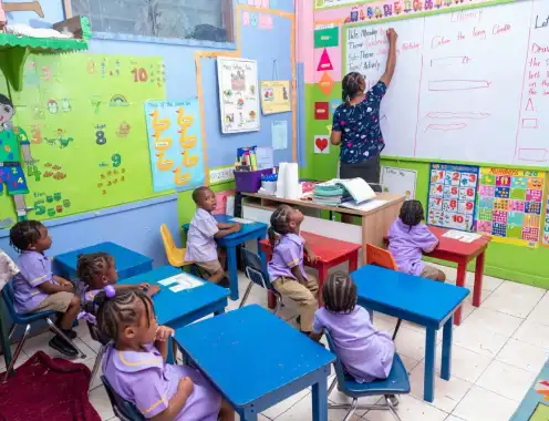 How is RIU Hotels driving child education in the Bahamas and Jamaica through its Proudly Committed strategy?