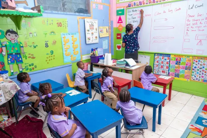 How is RIU Hotels driving child education in the Bahamas and Jamaica through its Proudly Committed strategy?